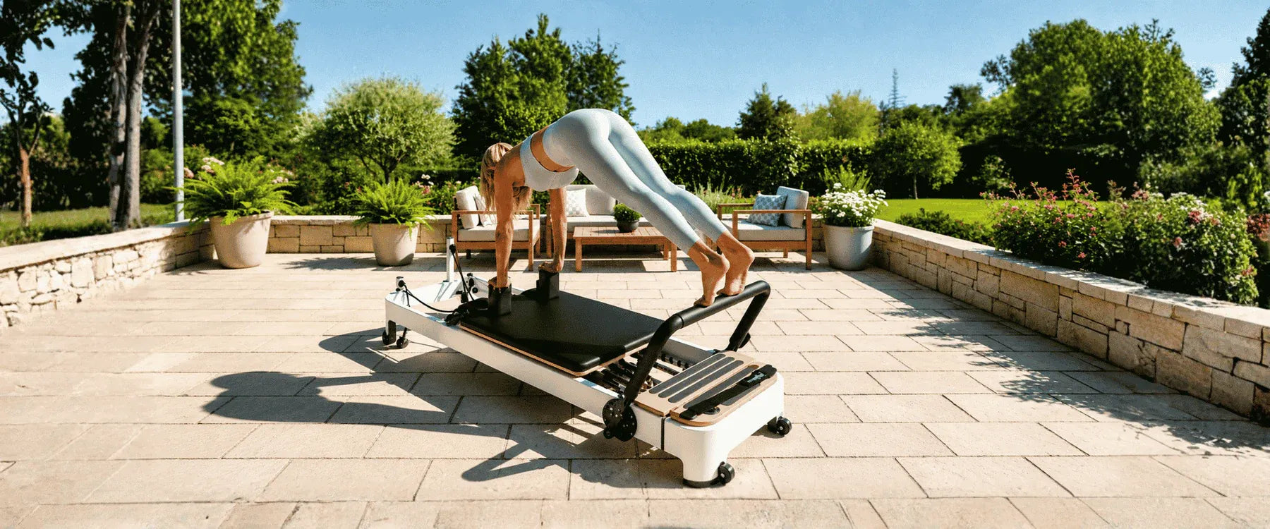 Woman exercising on an at-home Pilates reformer outdoors on a sunny garden patio – USA Wellness Champions.